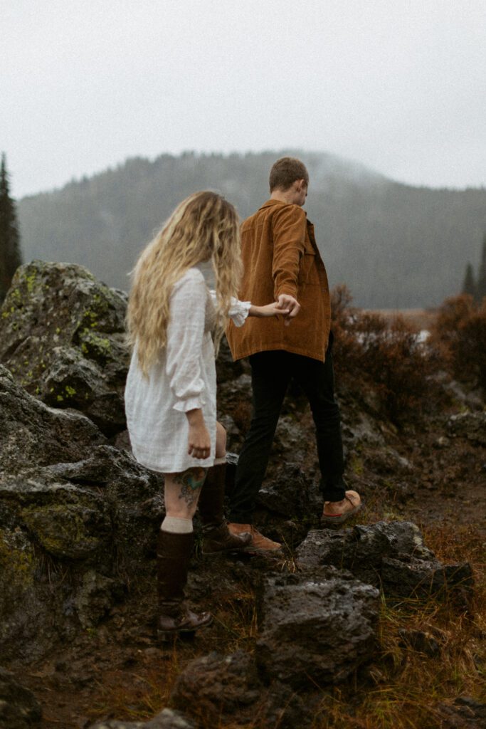 couple walks up lava rock at Sparks Lake